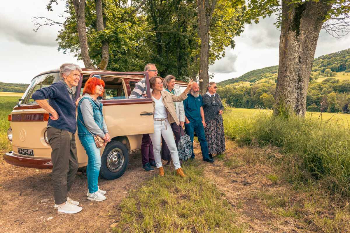 Un petit groupe adossé à un combi et regardant le paysage