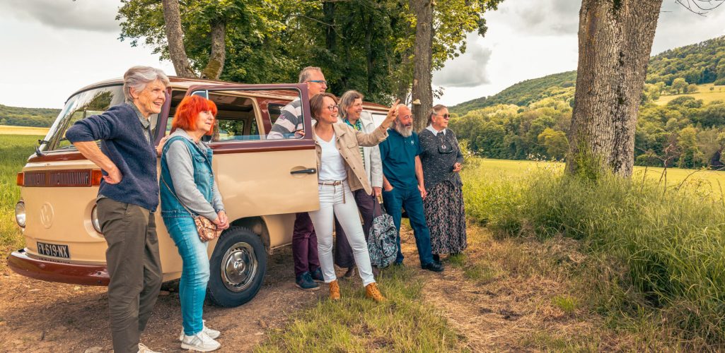 Un petit groupe adossé à un combi et regardant le paysage