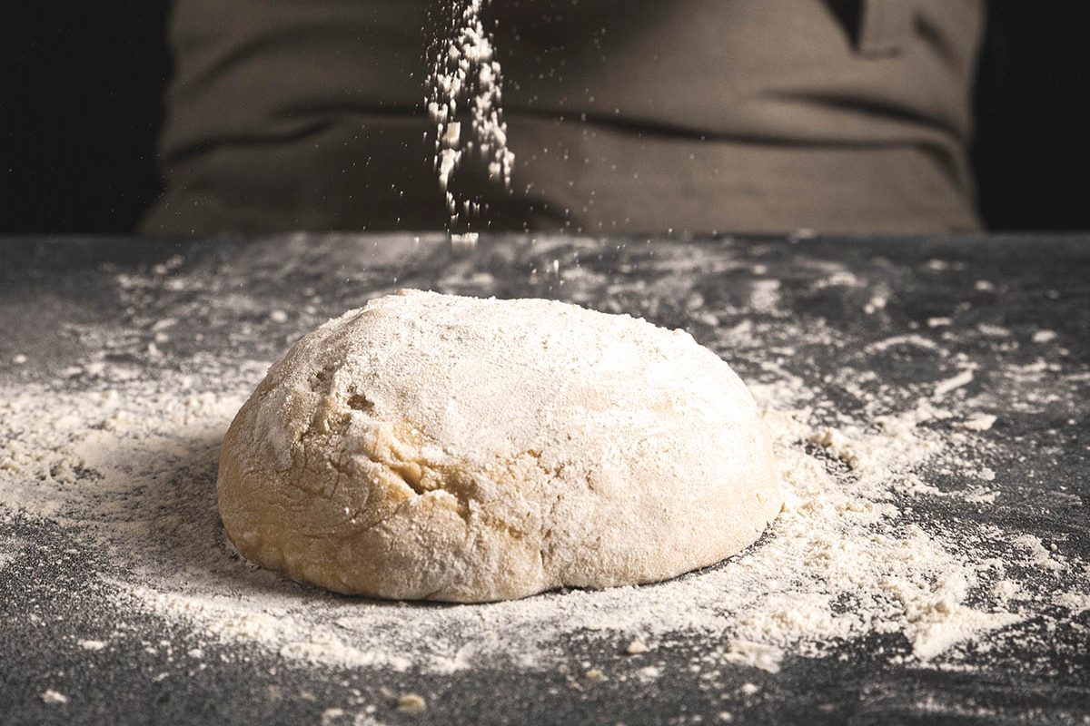 close-up-baker-hands-spreading-flour-W